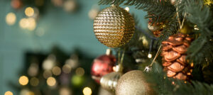 Closeup of part of a Christmas tree decorated with lights and ornaments.