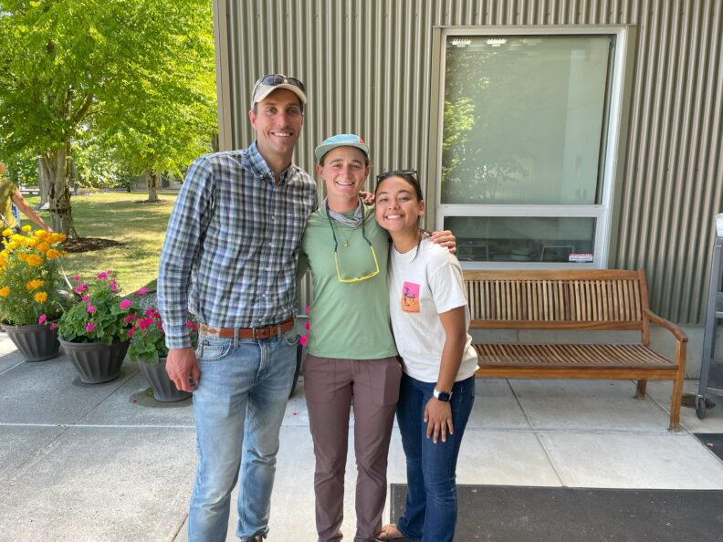 Three people standing in front of a building.