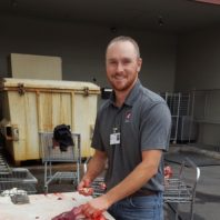 Mike Mosier with a knife and piece of deer meat.