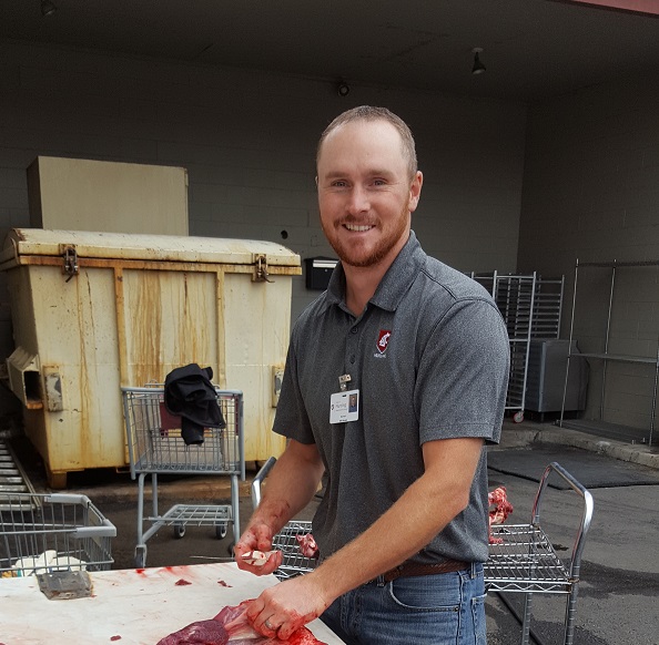 Mike Mosier with a knife and piece of deer meat.