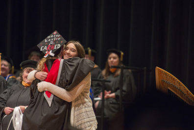 Young woman hugging an older woman.