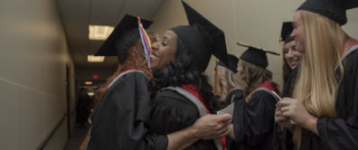 Two students hug at convocation ceremony