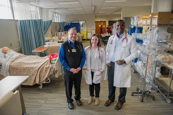 three DNP students in white coats 
