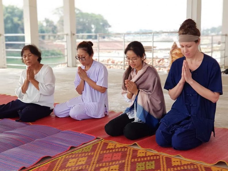 four people praying in Thailand