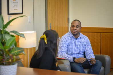 Nurse practitioner student talks to a person in an office