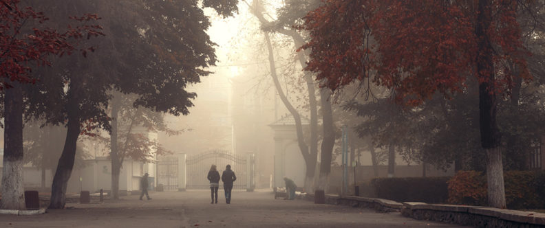 two people walking on a college campus during wildfire smoky season