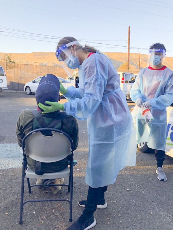 student administers covid test