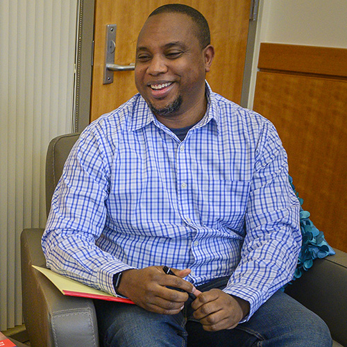 Male DNP student sitting in chair with notebook