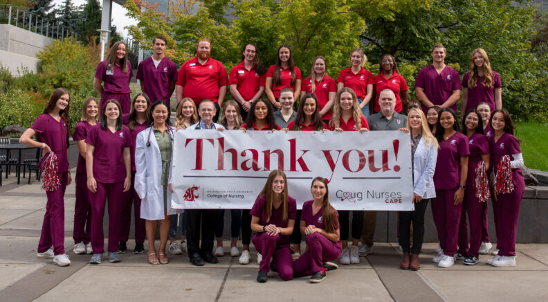 A group of nursing students holding a large banner that reads "Thank you!"