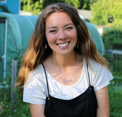 Chantal Krystiniak smiling in an outdoors scene holding a flower.
