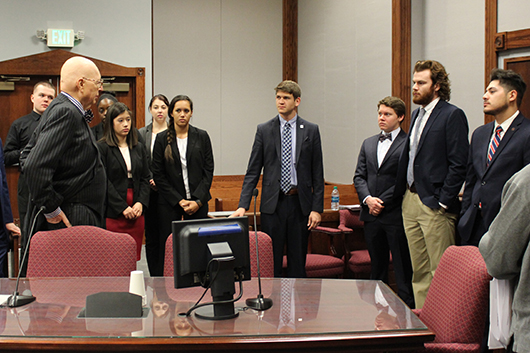 Group photo of the judge speaking with students.