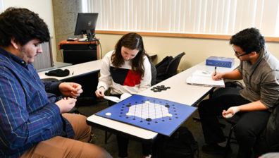 Three students playing a board game.