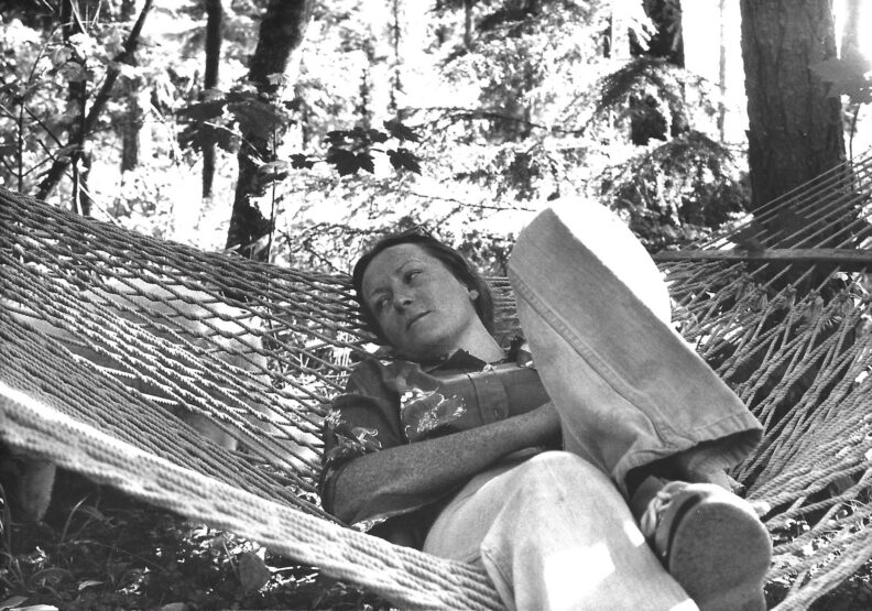 A woman lounges on a hammock. Black and white photo.