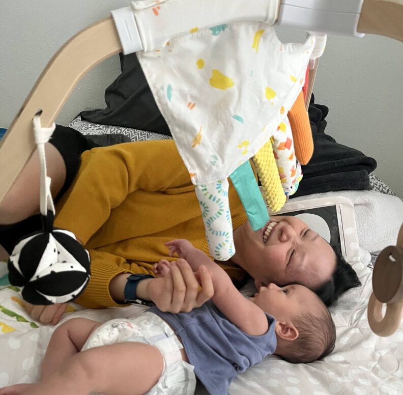 Thuy lies down beside her infant son.