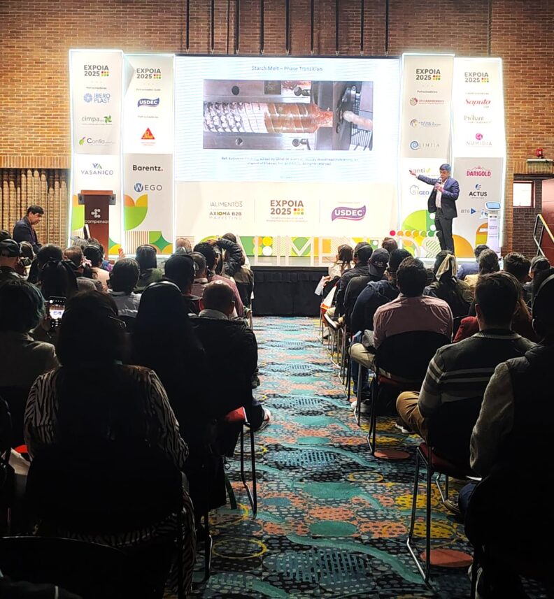 A crowd of people are seated for Girish's presentation. He stands on stage, discussing Starch Melt and Phase Transition.