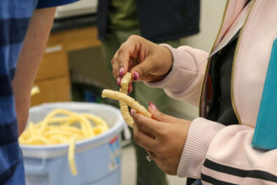 A woman holds up two extruded puffs in her hands.