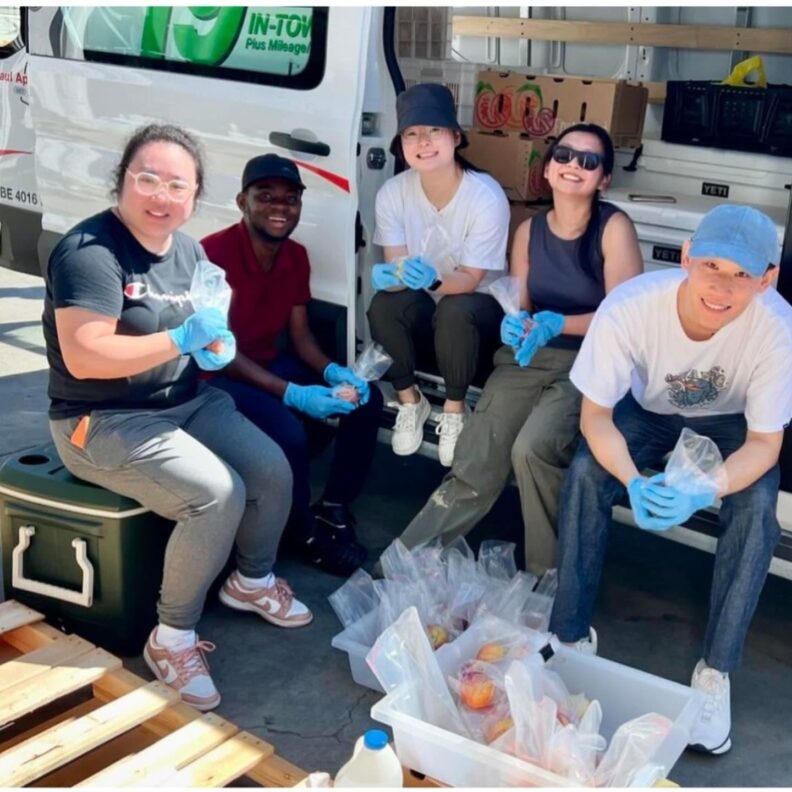 Edmund and other students from the Zhu lab package apples into plastic bags.