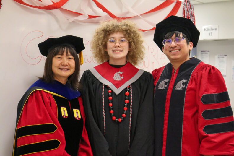 Two students, Alejandro and Morgan, stand with their major professor, Meijun Zhu.