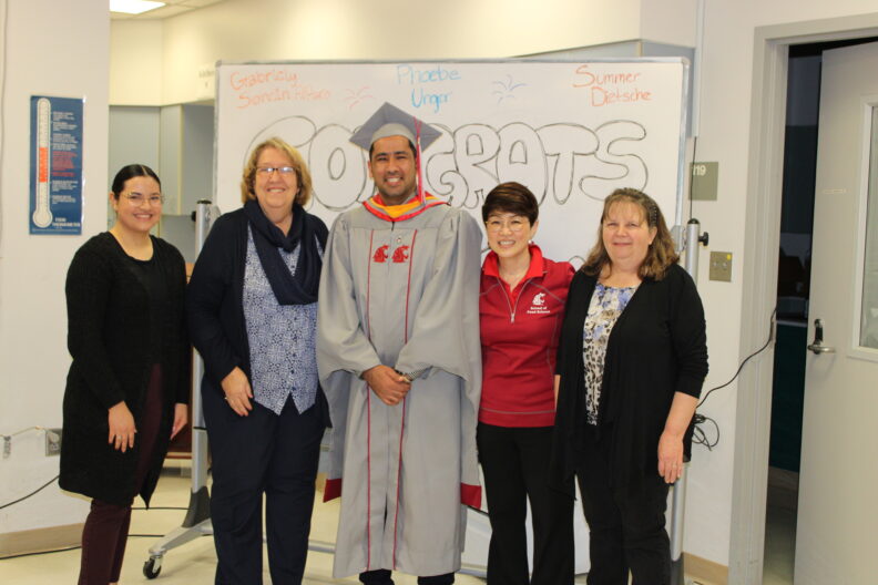 Barakatullah stands in masters graduate regalia. Beside him are Jodi Anderson, Mariana Castro, Soo-Yeun Lee, and Jane Lawford.