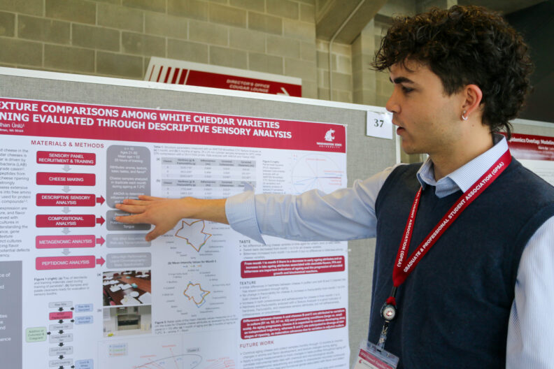 Jayden gestures to a portion of his research poster.
