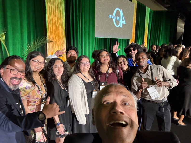 Paul amongst a big group of people smiling and posing for their picture.