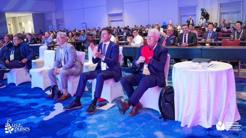 A crowd of people sit and clap at Dr. Ganjyal's presentation.