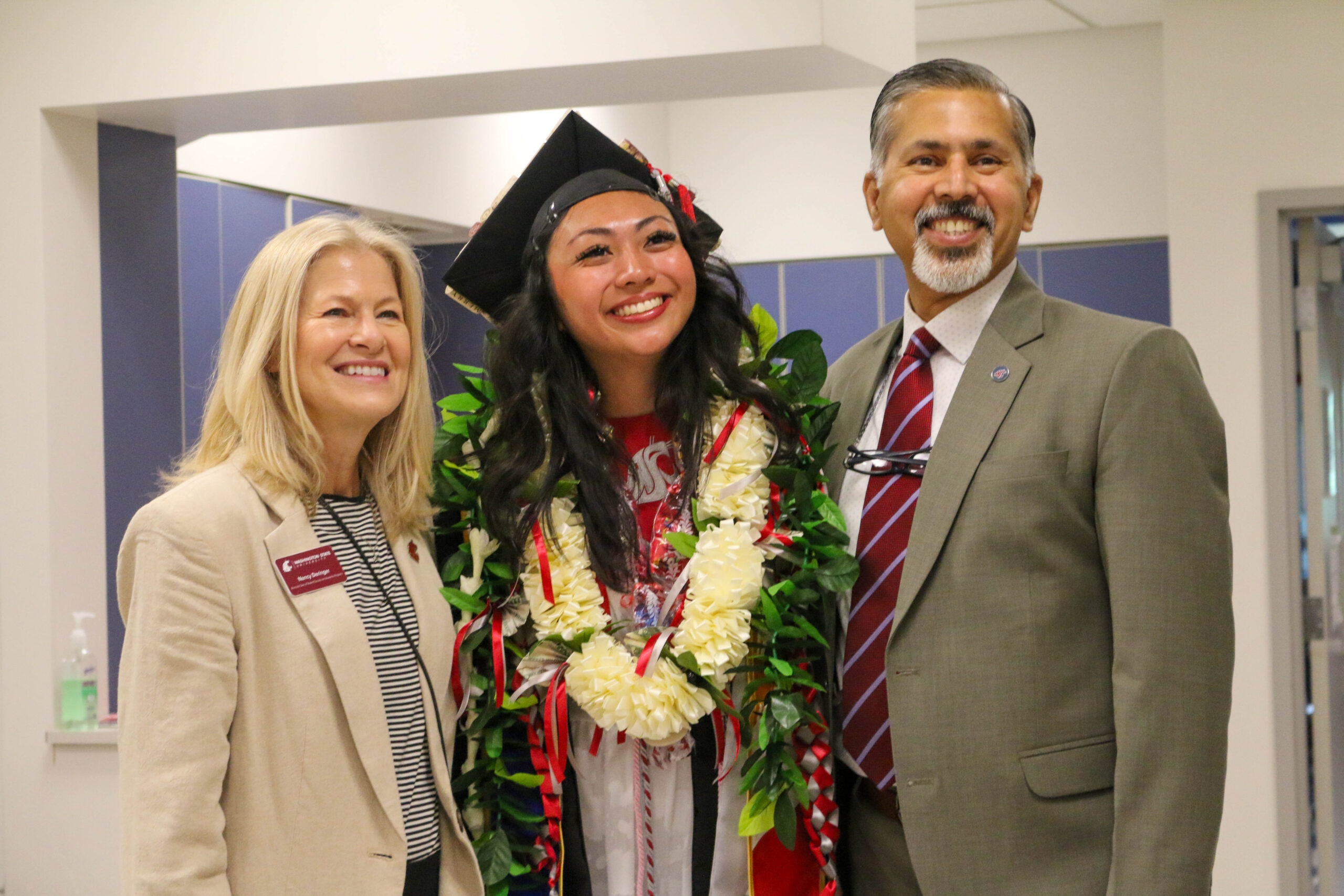 A graduating student stands between two CAHNRS Deans.