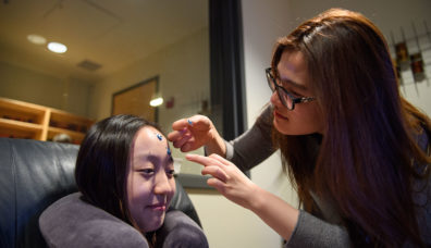 Student placing electrodes on subjects forehead