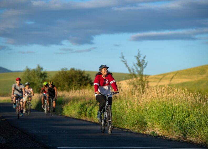 A group of students riding bicycles on a trail.