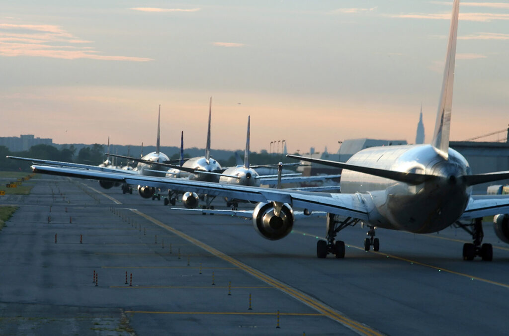 Planes lined up on the tarmac awaiting takeoff.