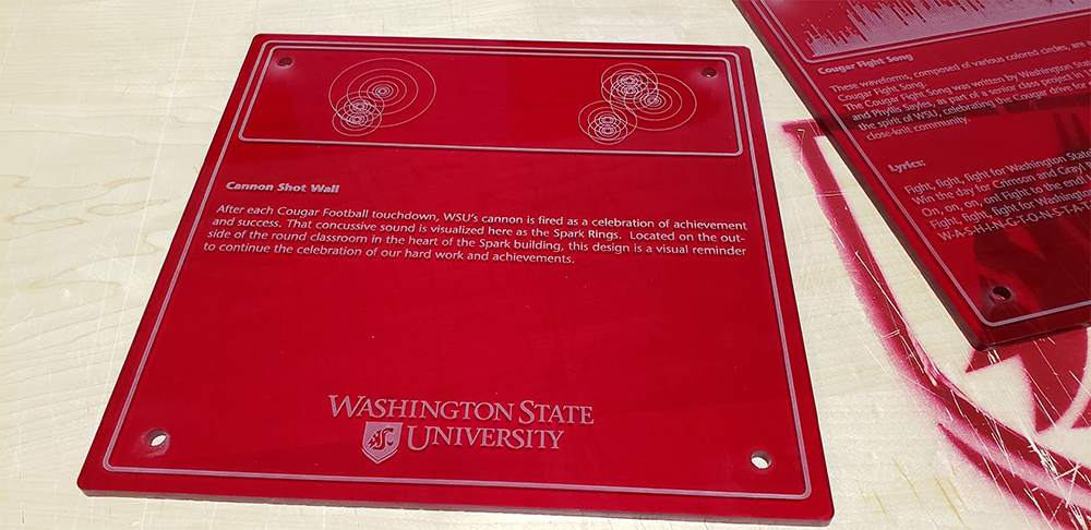 Photo: Wall plaque of Cannon Shot Wall. After each Cougar Football touchdown, WSU's cannon is fired as a celebration of achievement and success. That concussive sound is visualized here as the Spark Rings. Located on the outside of the round classroom in the heart of the Spark building, this design is a visual reminder to continue the celebration of our hard work and achievements.