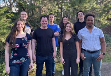 Group of eight people outdoors looking at the camera.