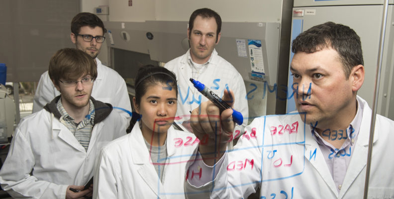 Chris Davis and his lab employees are shown in white coats