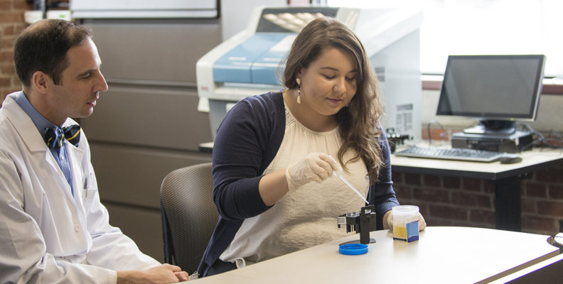 Addictions researcher Michael McDonnell watches as a lab staff member tests a urine sample for alcohol abstinence.