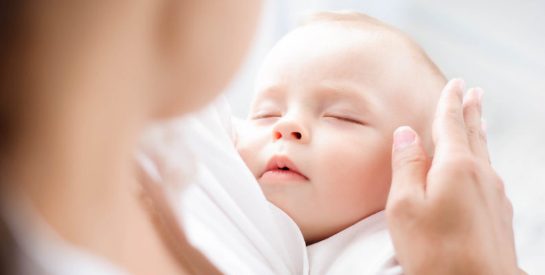 Image of baby sleeping in mother's arms