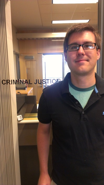 Zach Hamilton at the door of the Department of Criminal Justice & Criminology.