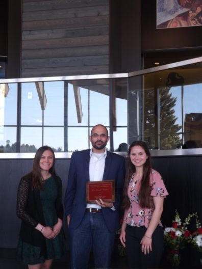 Dr. David Makin, center, holds his award placque, flanked by students Samantha Bill & Emma Smith.