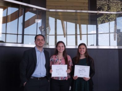 Dr. Dale Willits stands with students Emma Smith & Samantha Bill, who are holding award certificates..