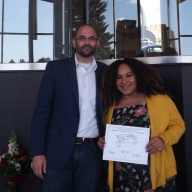 Dr. David Makin stands with Aushanae Matthews, who is holding her award certificate..