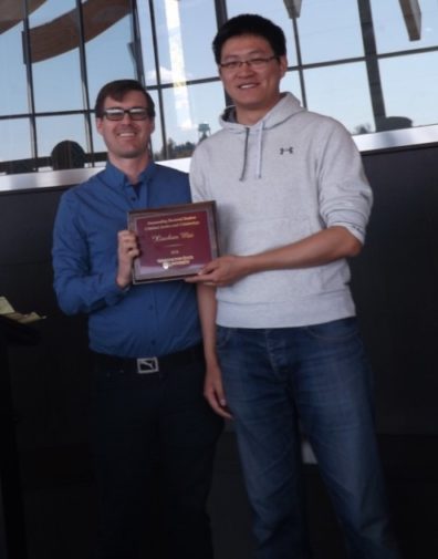 Dr. Zachary Hamilton hands Xiaohan Mei his award placque..