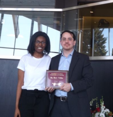 Brianne Posey presents Dr. Dale Willits with his award placque..