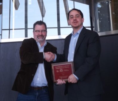 Dr. Craig Hemmens congratulates Dr. Dale Willits with a handshake and award placque..