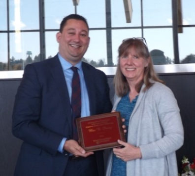 Alumnus Mac B. Pevey receives his award placque from Professor Faith Lutze.
