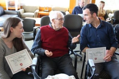 Jim Short, sitting in the center, converses with two students, Alana Inlow, sitting on the left, and Adam Roth, sitting on the right, at the awards banquet.