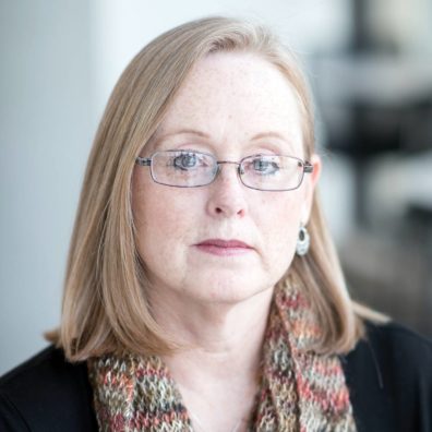 A front facing photo of Deborah Thorne, from the shoulders up. She is looking into the camera.