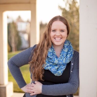 Katie is pictured from the waist up and is smiling towards the camera.