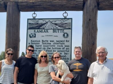 The group is lined up and smiling in front of the Kamiak Butte sign.