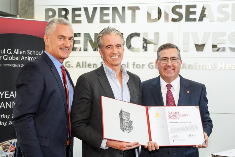 Guy Palmer receiving award from WSU President Kirk Schulz and Executive Director of Alumni Association, Tim Pavish