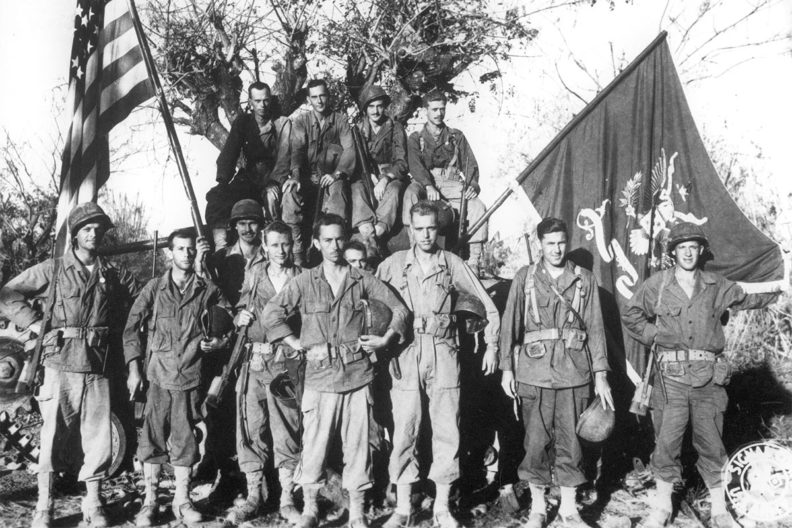 Members of the 161st with the U.S. flag and regimental colors. Photo was taken in the Pacific Theater at an unknown location sometime between 1943 and 1945. Image courtesy of the National Guard Museum, Camp Murray, Washington.
