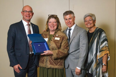 Clinical Associate Professor Melody Rasmor, second from left, received the Real Hero award from project sponsor representatives (left to right): Ryan Hart, Port of Vancouver USA; Chris Hill, Northwest Capital Mortgage; and Lorre Jaffe, Real Living The Real Estate Group.